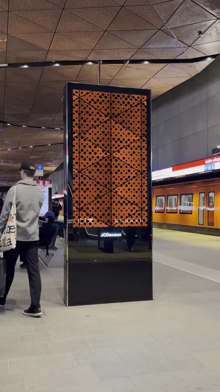 Orange motion poster at Aalto University station